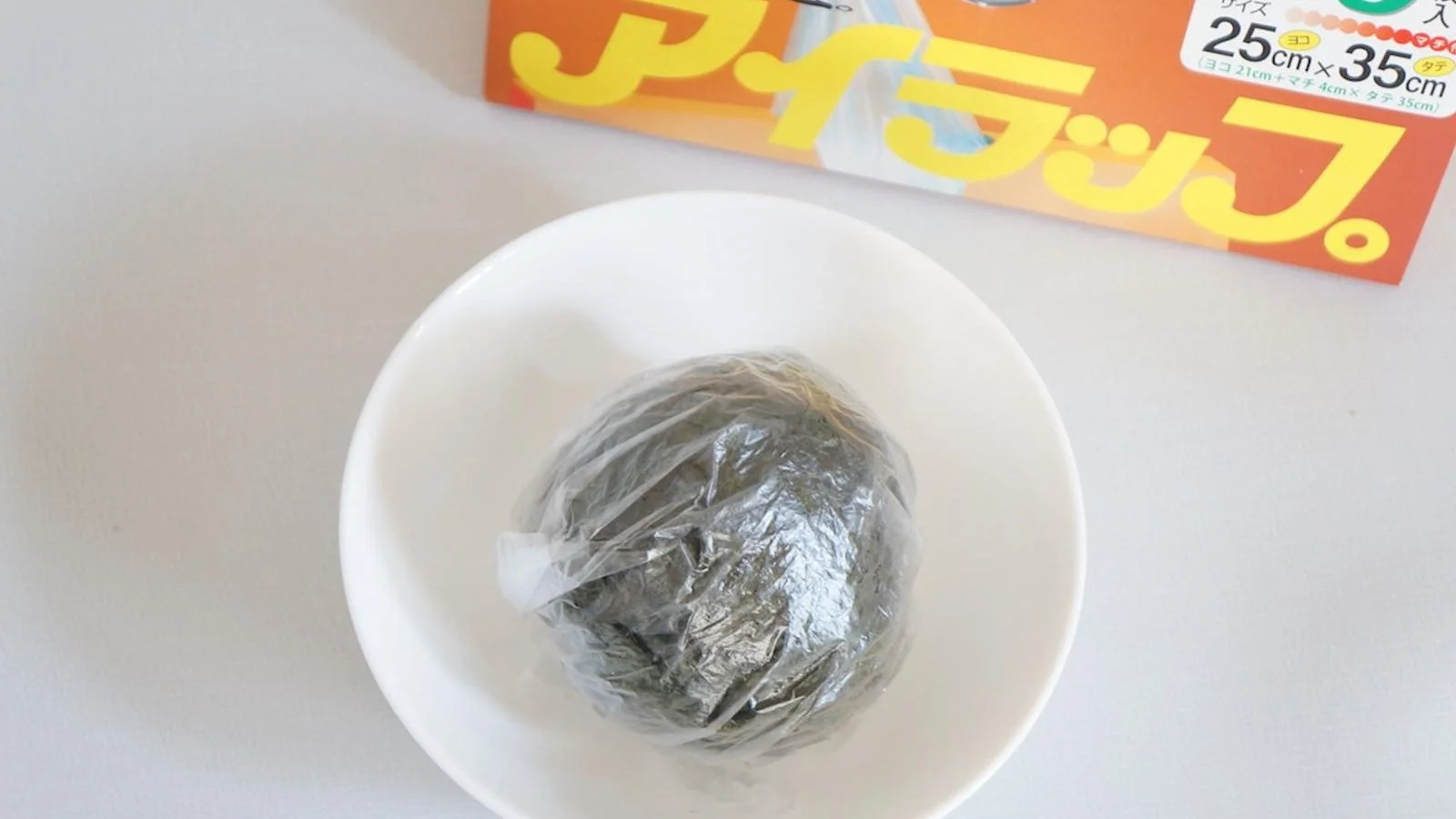 The wrapped ball back in the plastic bag, resting in a bowl